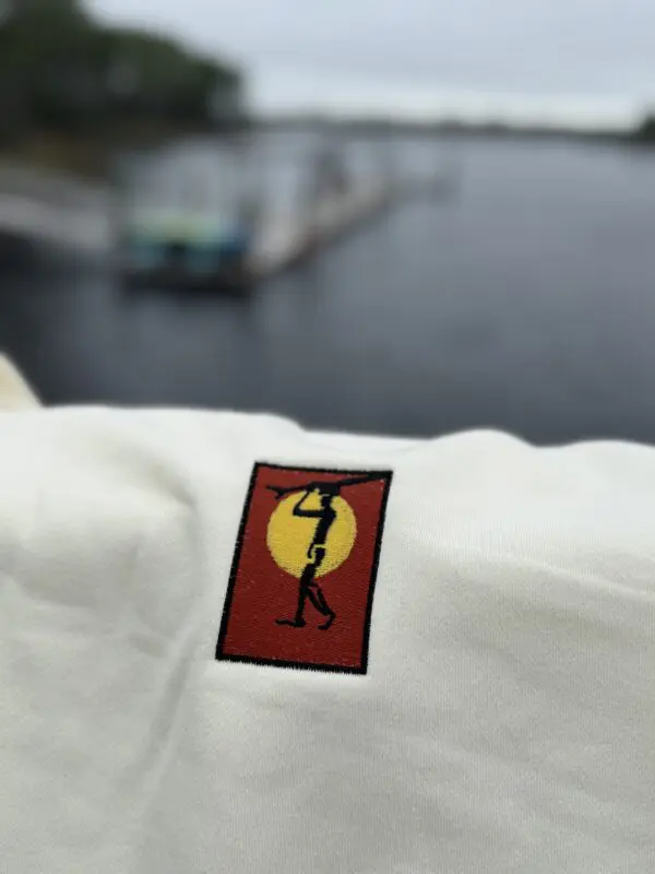 Embroidered shirt with sun and figure.